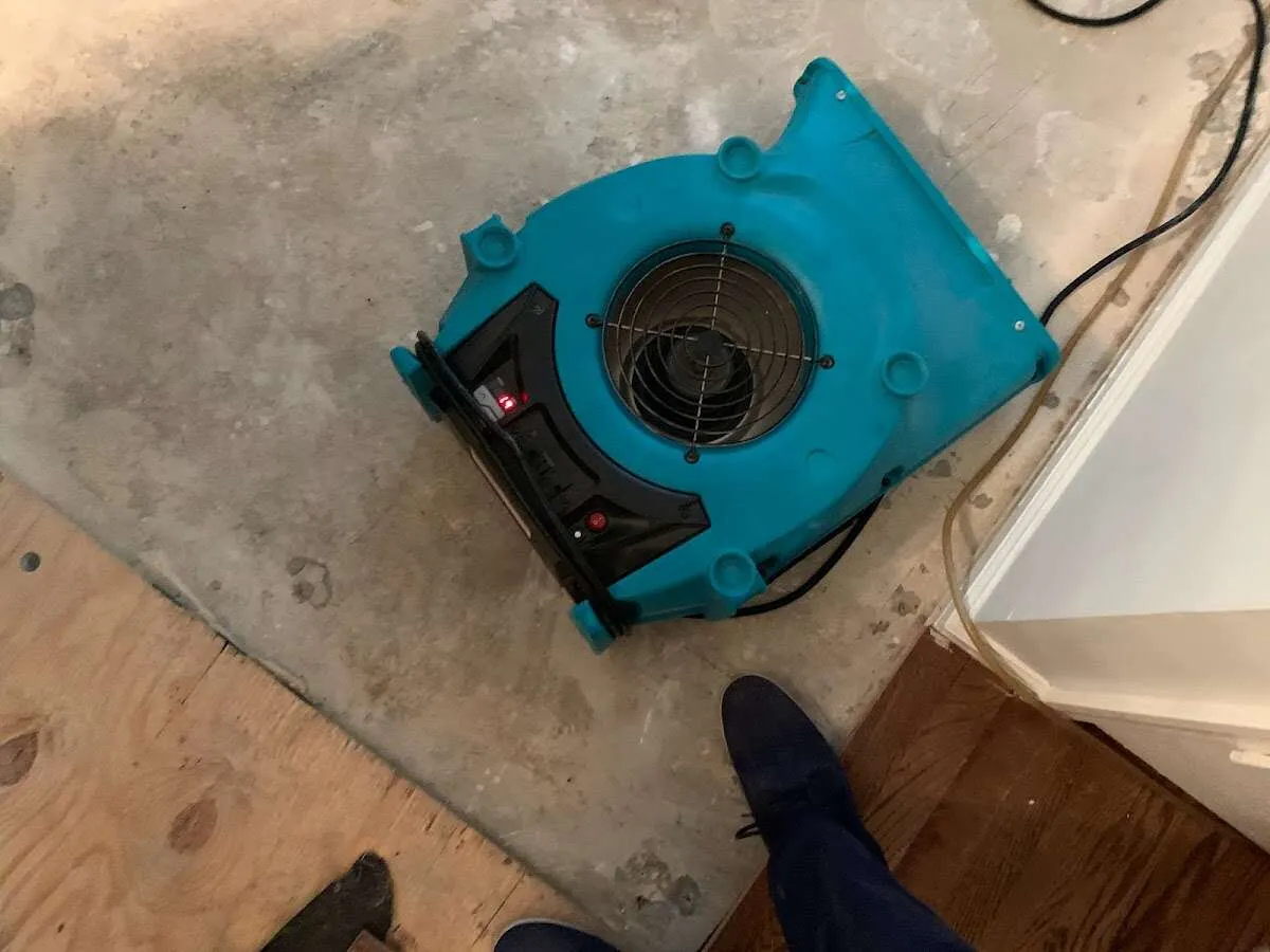 Air mover drying subfloor during Commercial Water Damage Restoration in East Greenwich